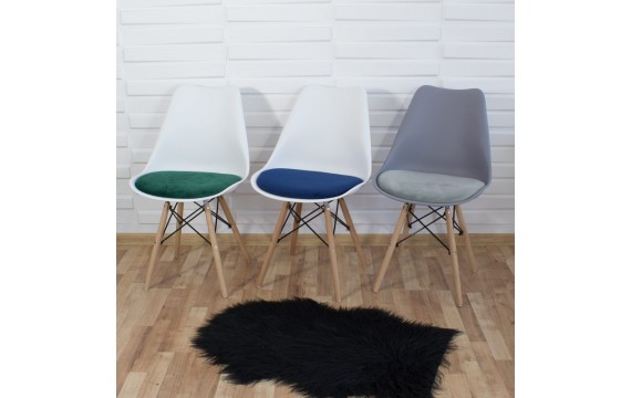 A modern chair with a velvet gray cushion on wooden beech legs, several colors